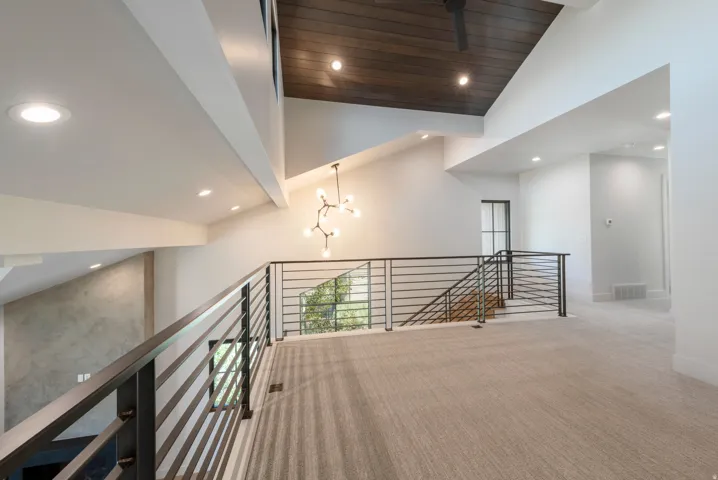 Vaulted ceilings with recessed lighting, dark wood-finish ceiling, modern chandelier, and horizontal bar railings