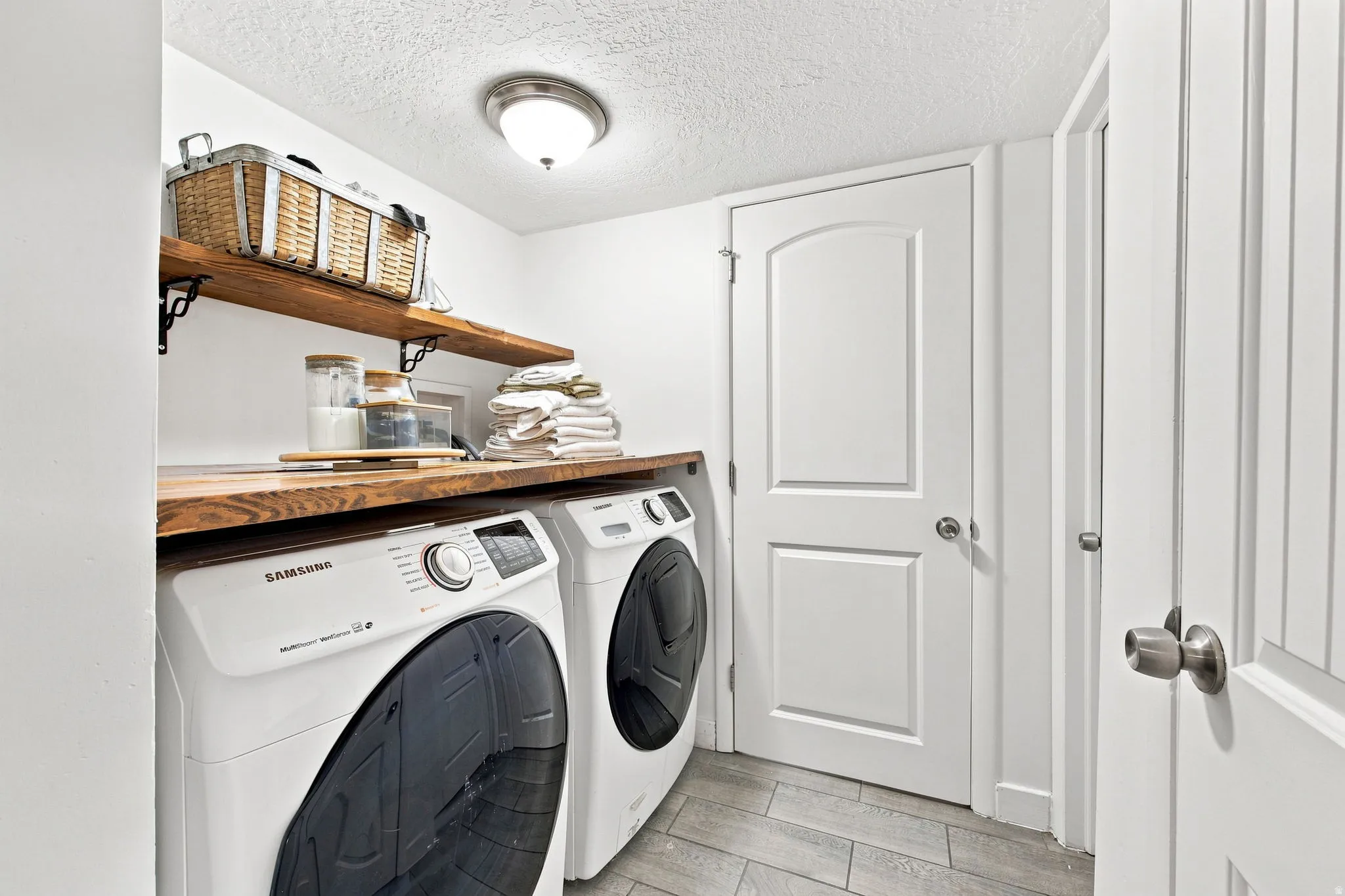 Wood-finish countertops with built-in shelving, tile flooring, and overhead lighting