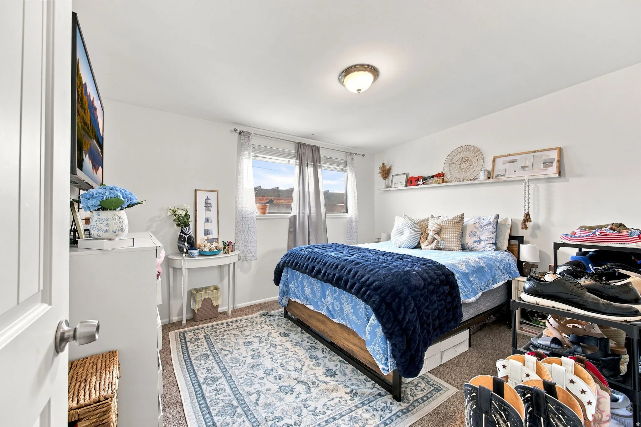 Built-in shelving, natural light from multiple windows, wall-mounted television, and overhead lighting