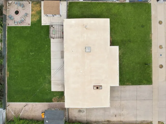 Extensive concrete driveway, flat roofline, and generous grassy areas
