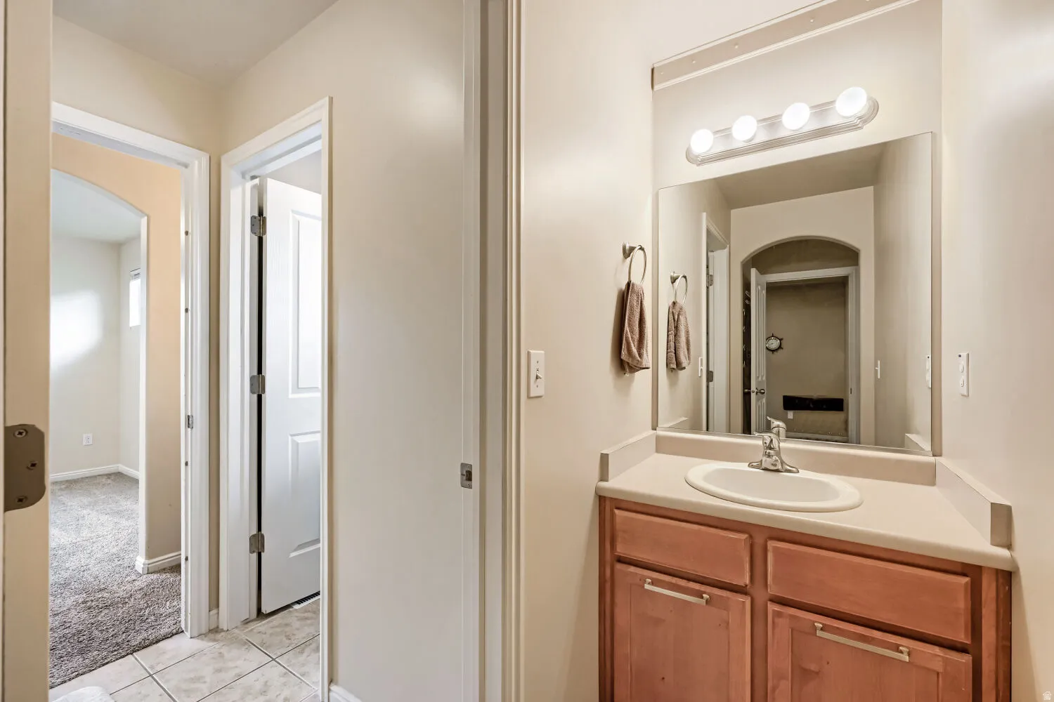 Vanity with a laminate countertop, integrated sink, and wood-finish cabinetry
