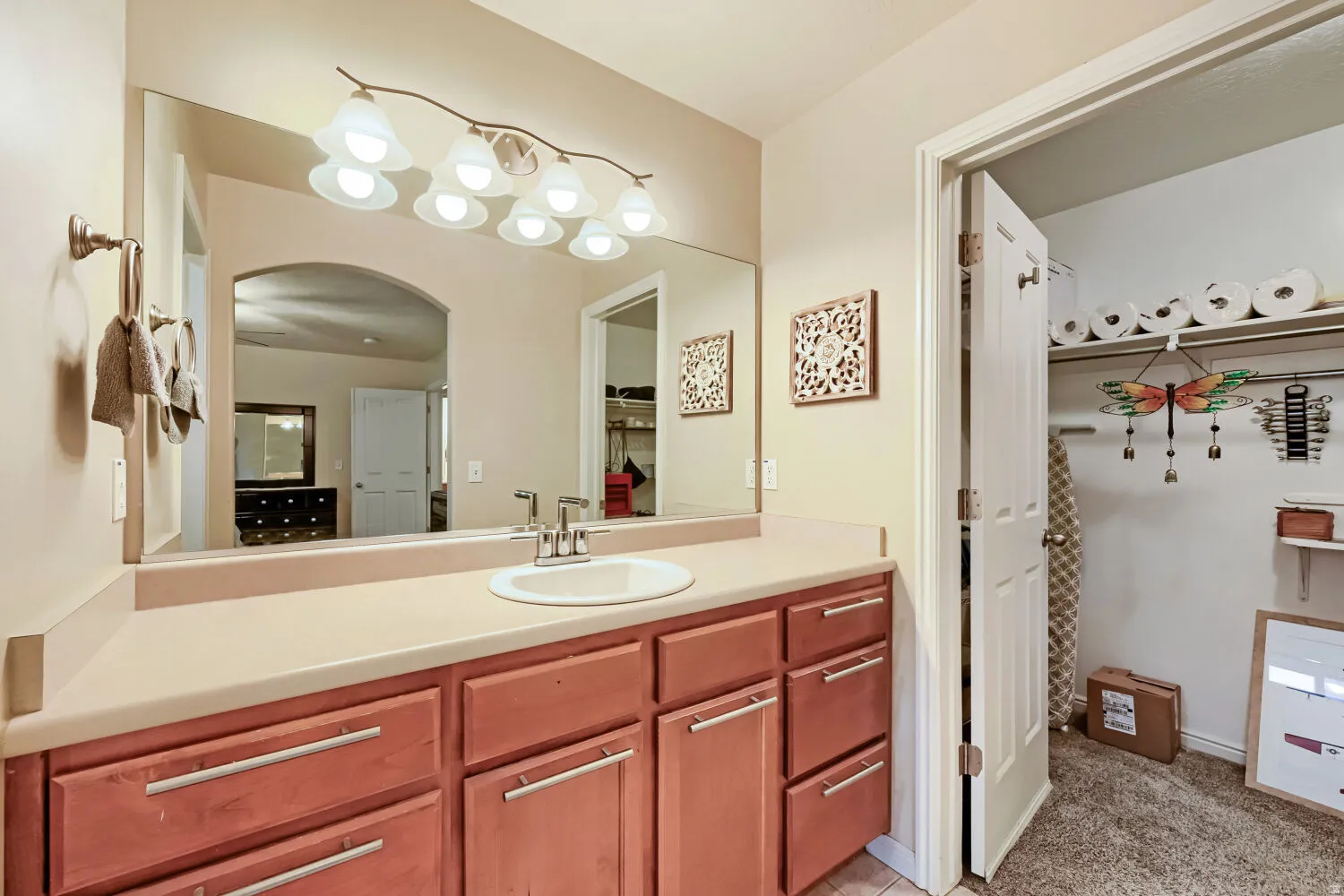 Single vanity with a light-toned countertop, integrated sink, and brushed nickel faucet