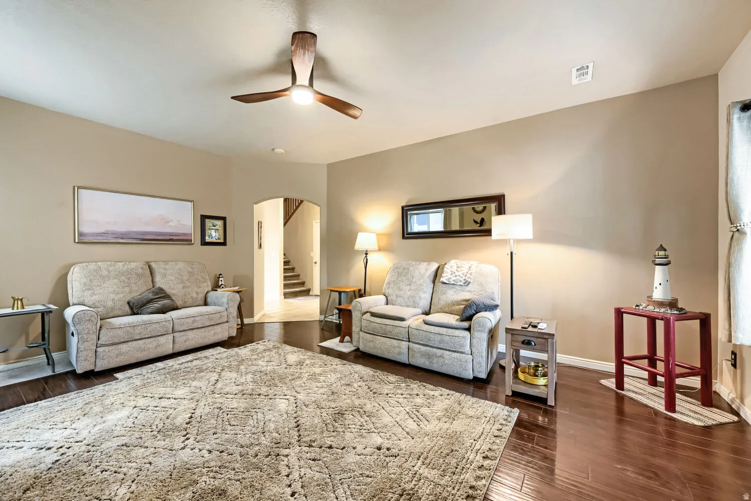 Rich wood-finish flooring with an arched entry