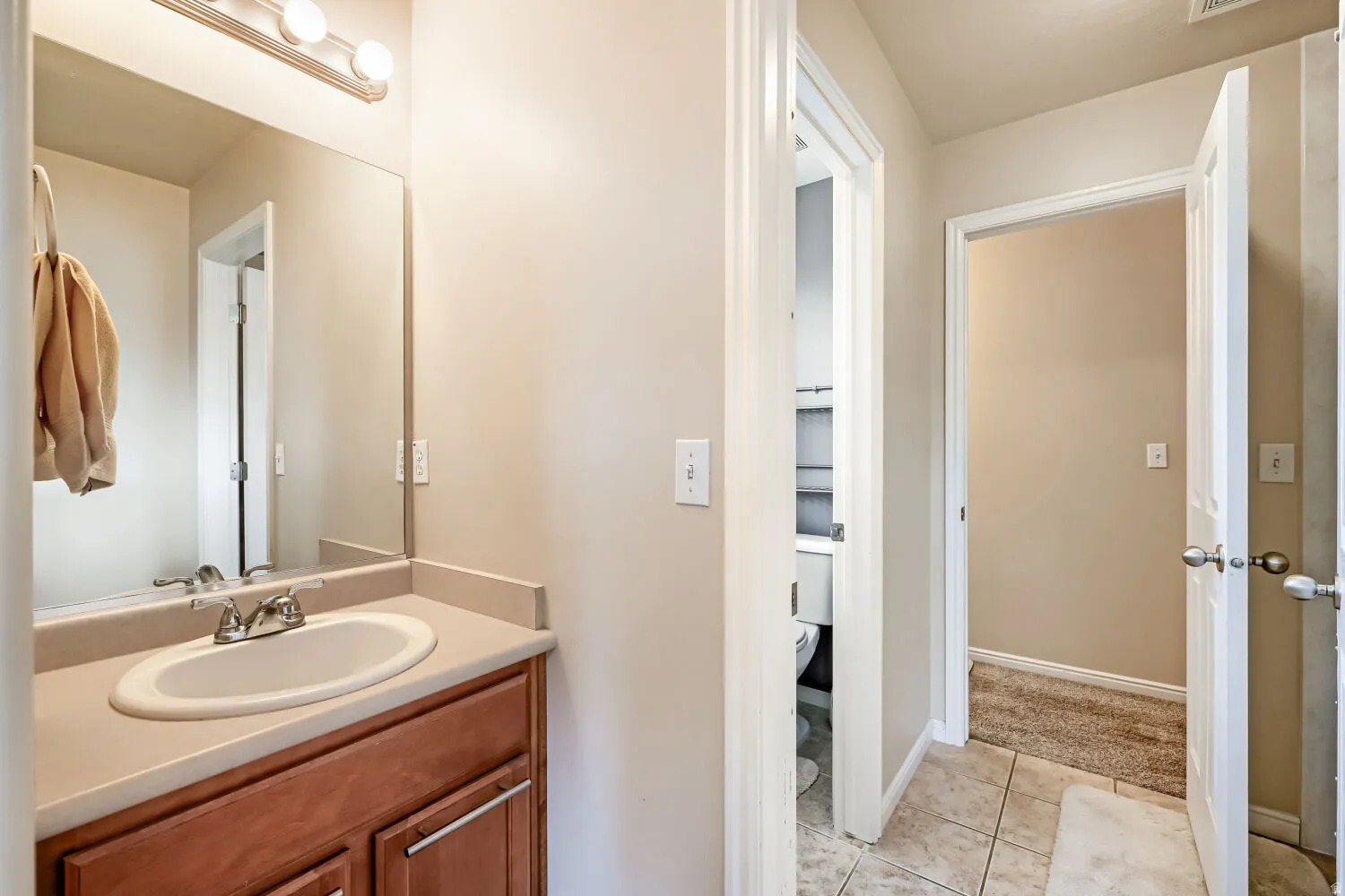 Vanity with a neutral countertop, undermount sink, and chrome-finish faucet