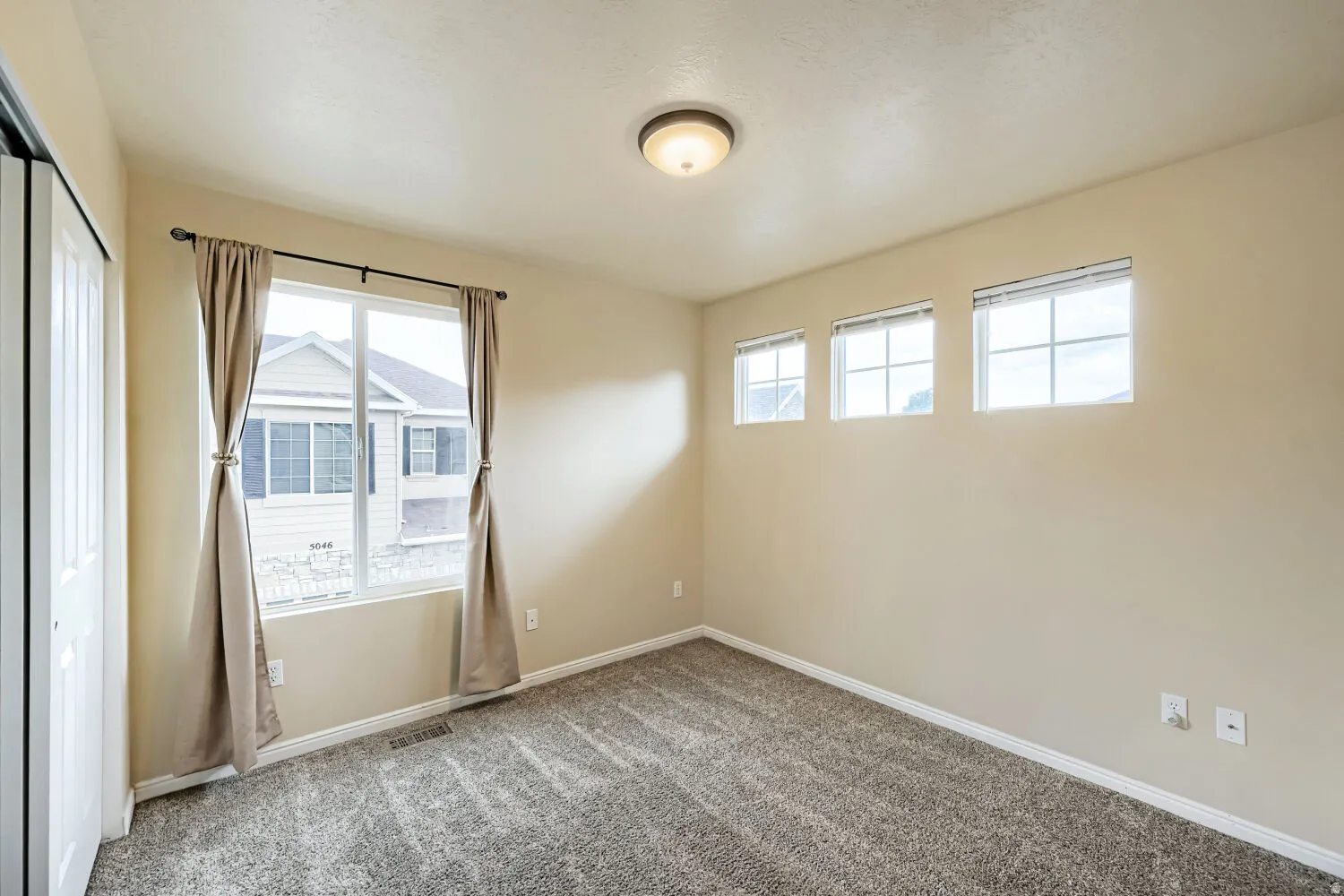 Neutral paint, plush carpet, recessed lighting, and multiple windows