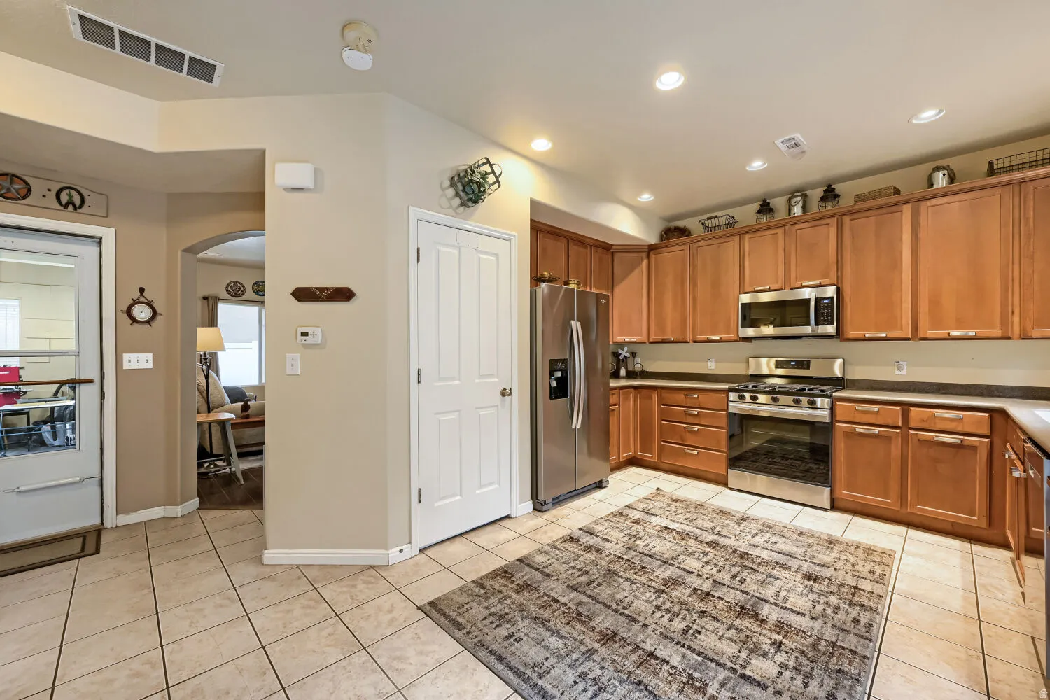 Kitchen featuring wood-finish cabinetry, stainless steel appliances, and tile flooring