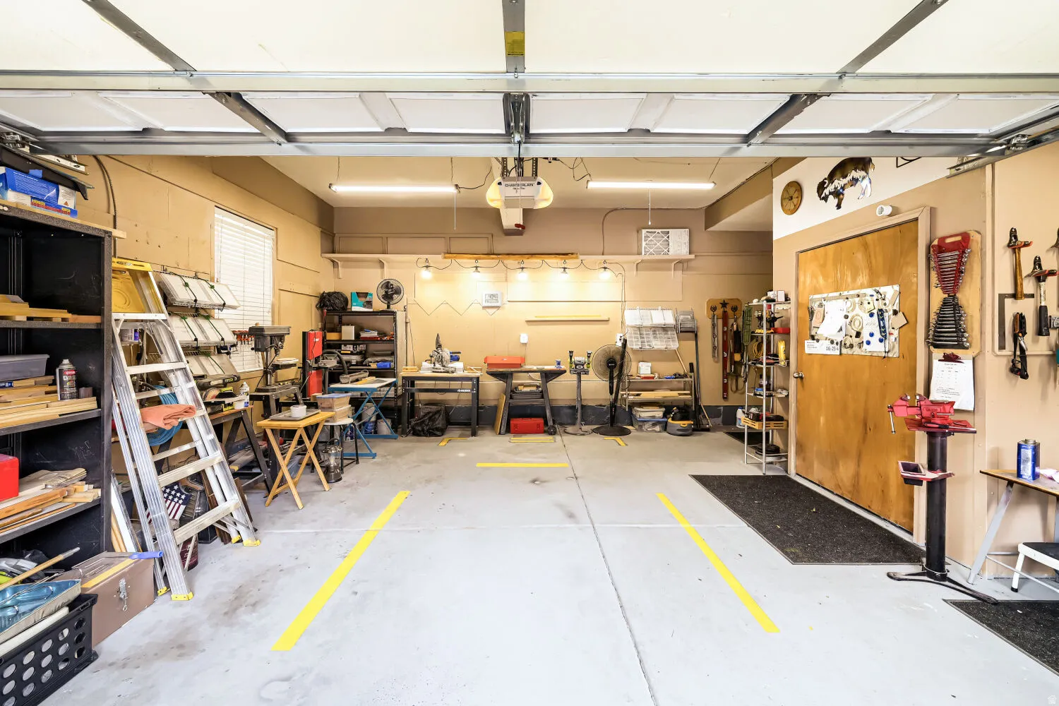 Attached garage featuring a concrete floor, built-in shelving, and a window with blinds