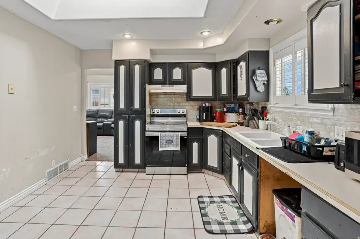 Kitchen featuring tile flooring, dark cabinetry, and white countertops