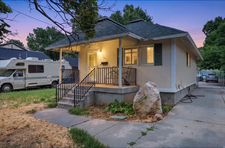 Covered entry porch with dark metal railings and steps
