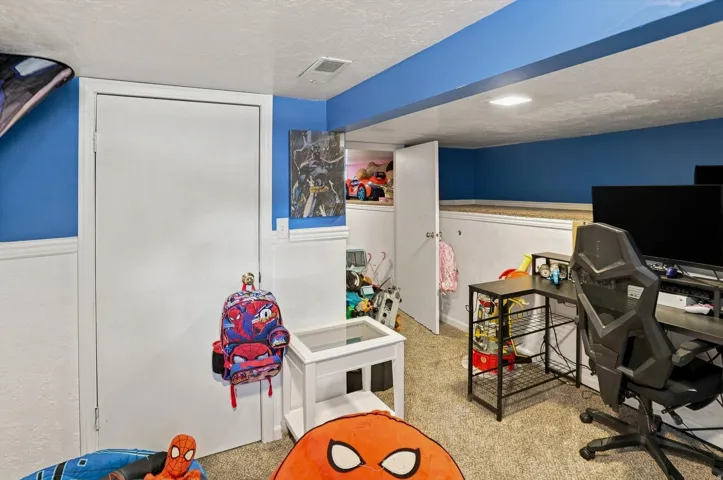 Carpeted flooring with white wainscoting and blue painted walls