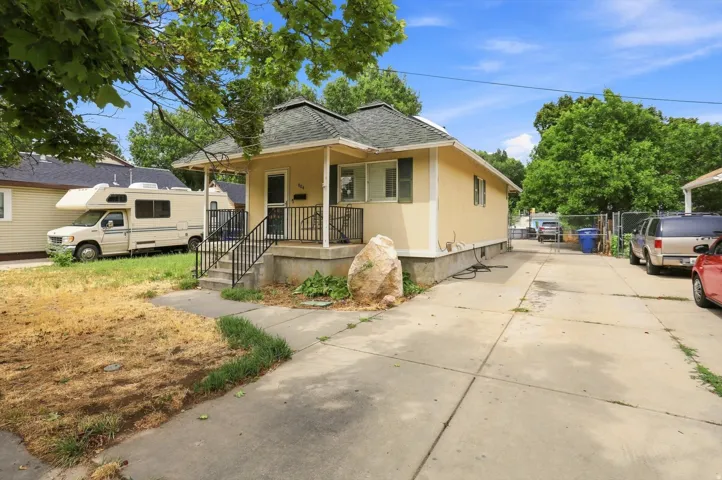 Covered front porch, established trees, and concrete driveway