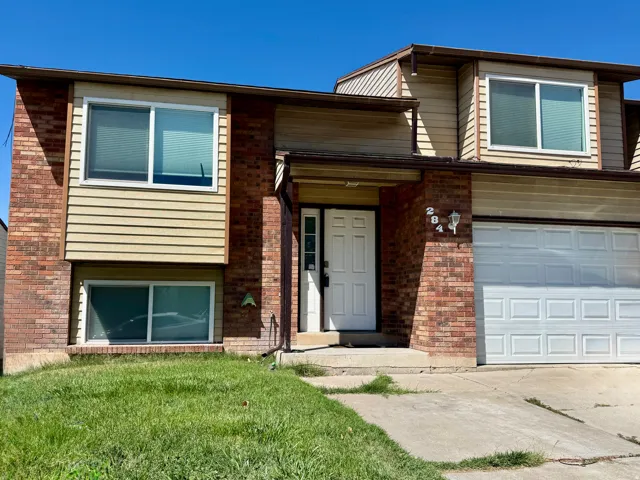 Brick and horizontal siding exterior with a white entry door, an integrated garage, and multiple windows