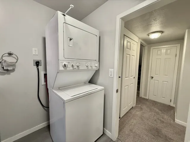 Compact stacked washer and dryer unit, neutral wall paint, and recessed ceiling light