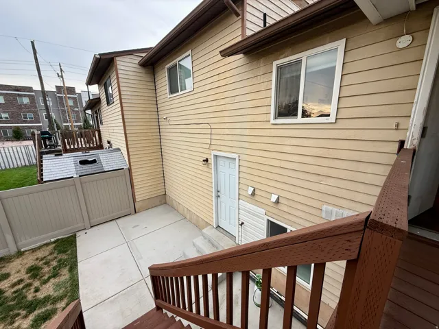 Exterior featuring horizontal siding, white-framed windows, and a dedicated patio area