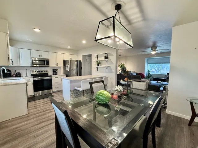 Kitchen with white shaker cabinetry, stainless steel appliances, and wood-finish flooring