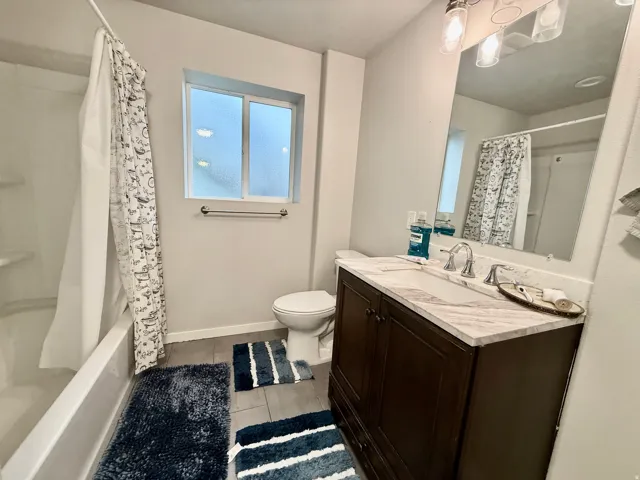 Wood-finish flooring with a white bathtub and shower surround