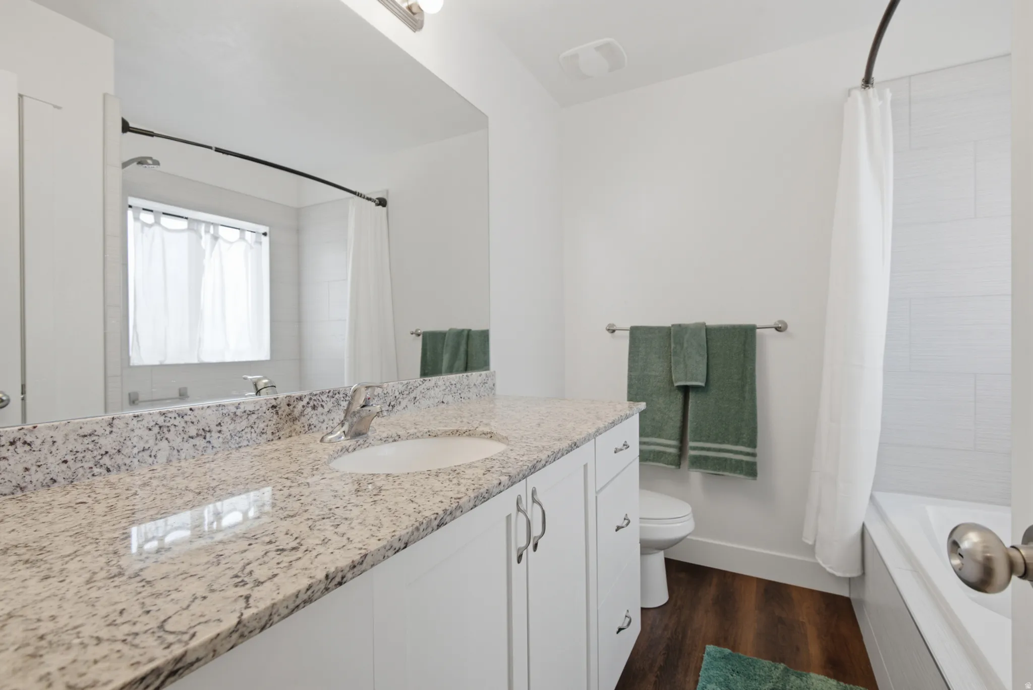 Vanity with granite-style countertop, undermount sink, and chrome faucet