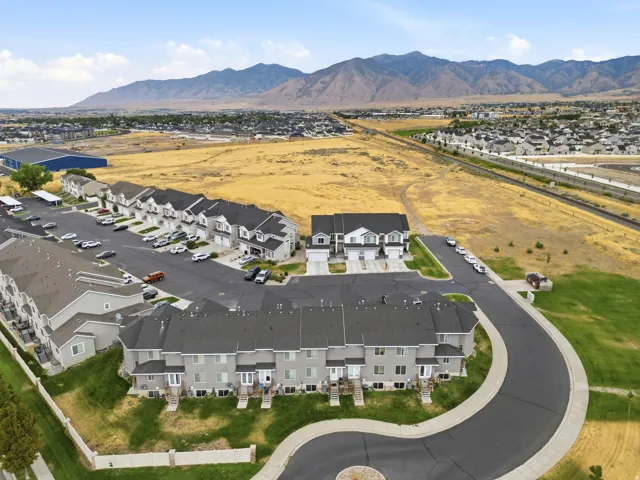 Newly constructed townhome community featuring modern architectural design with clean-lined exteriors, asphalt driveways, and professionally landscaped grounds