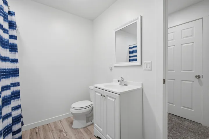 White vanity with an integrated sink, polished chrome faucet, and a rectangular framed mirror