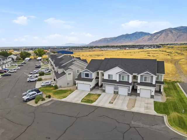 Row of attached residential units featuring individual garage entries and gray shingle roofing
