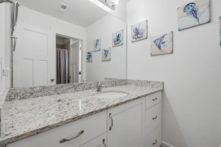 White vanity with integrated sink, granite countertop, and silver-tone hardware