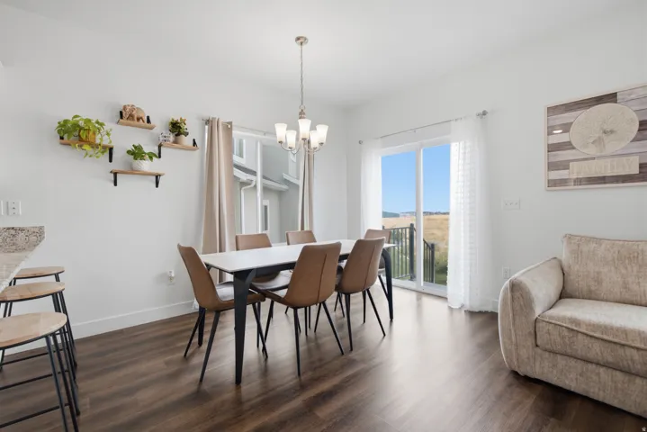 Wood-finish flooring throughout, white walls, and a multi-light pendant fixture