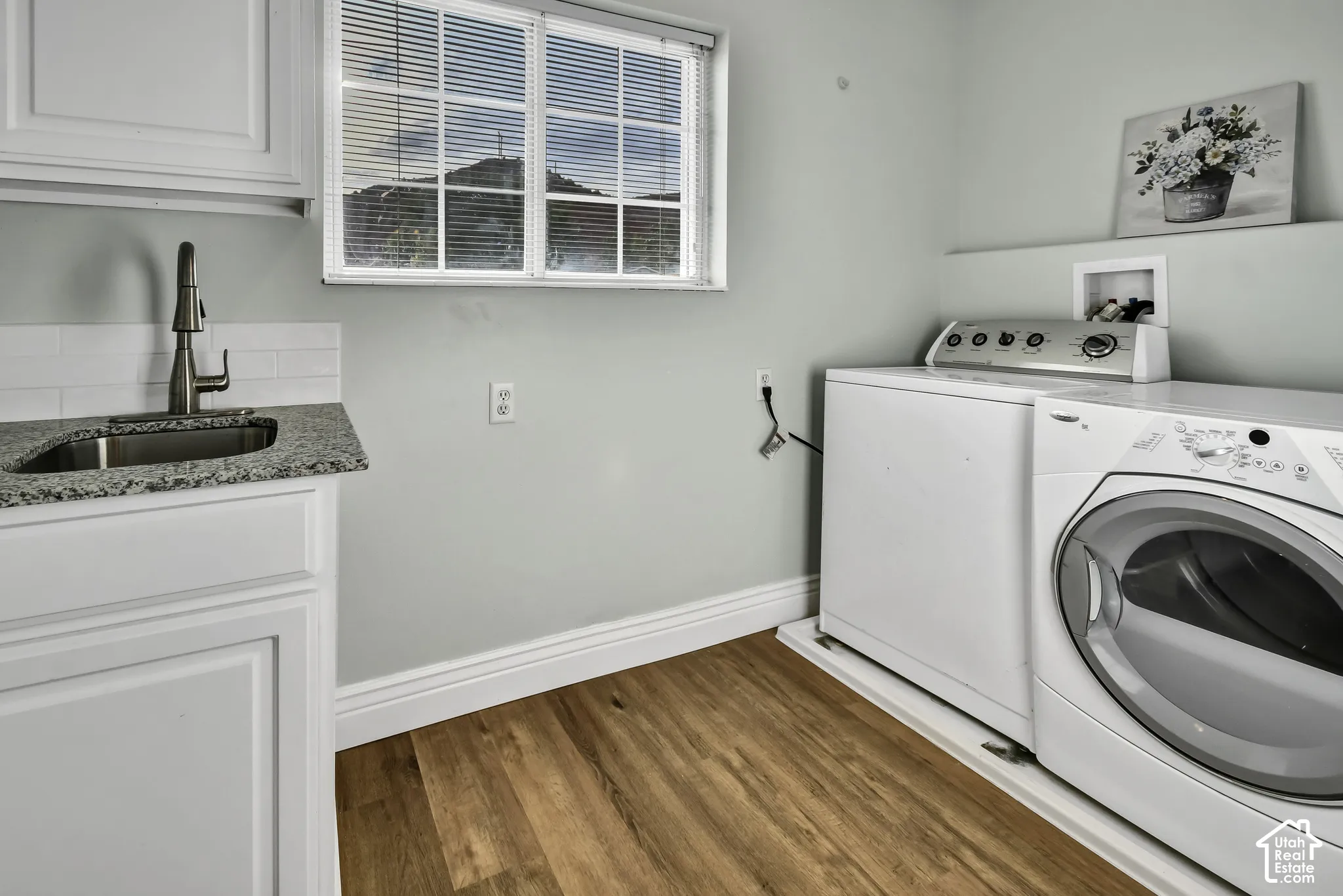 White shaker cabinetry with a granite countertop and undermount sink