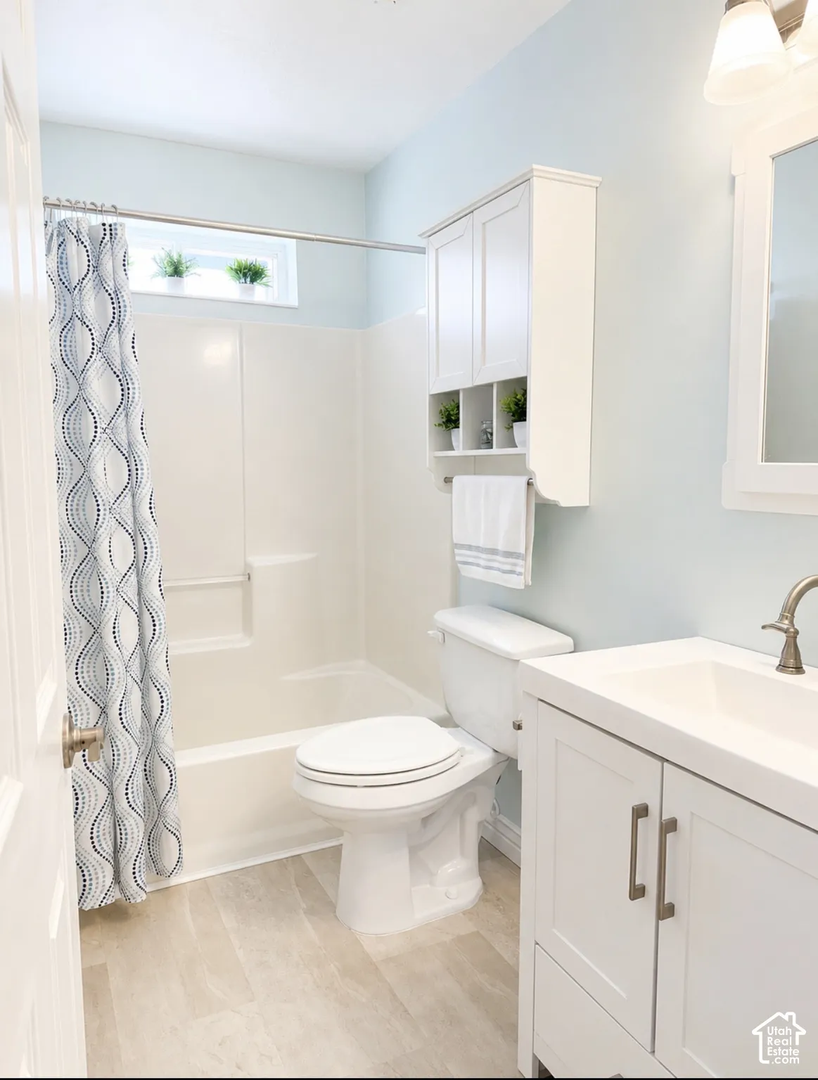 White vanity with brushed nickel hardware, integrated sink, and brushed nickel faucet
