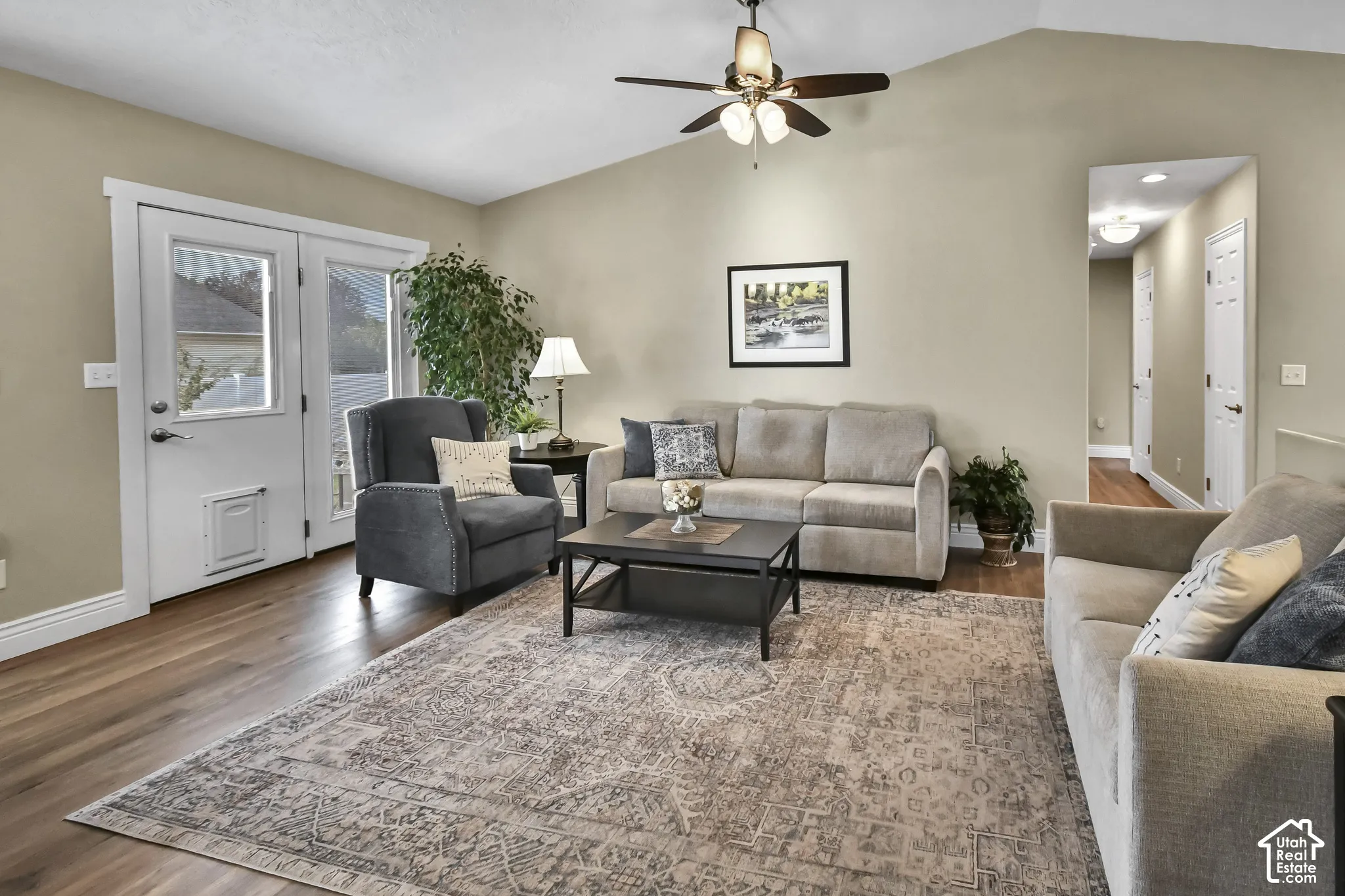 Vaulted ceilings, wood-finish flooring, and a ceiling fan with integrated lighting