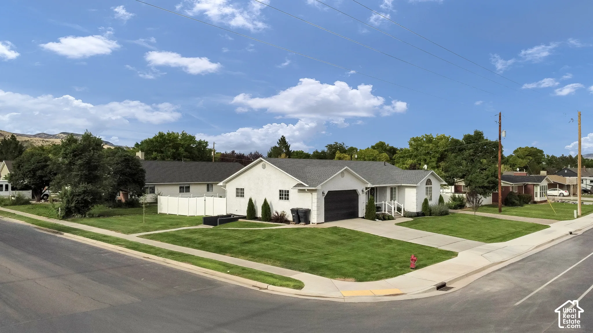 Single-story residence featuring a white stucco exterior and a dark gray roof