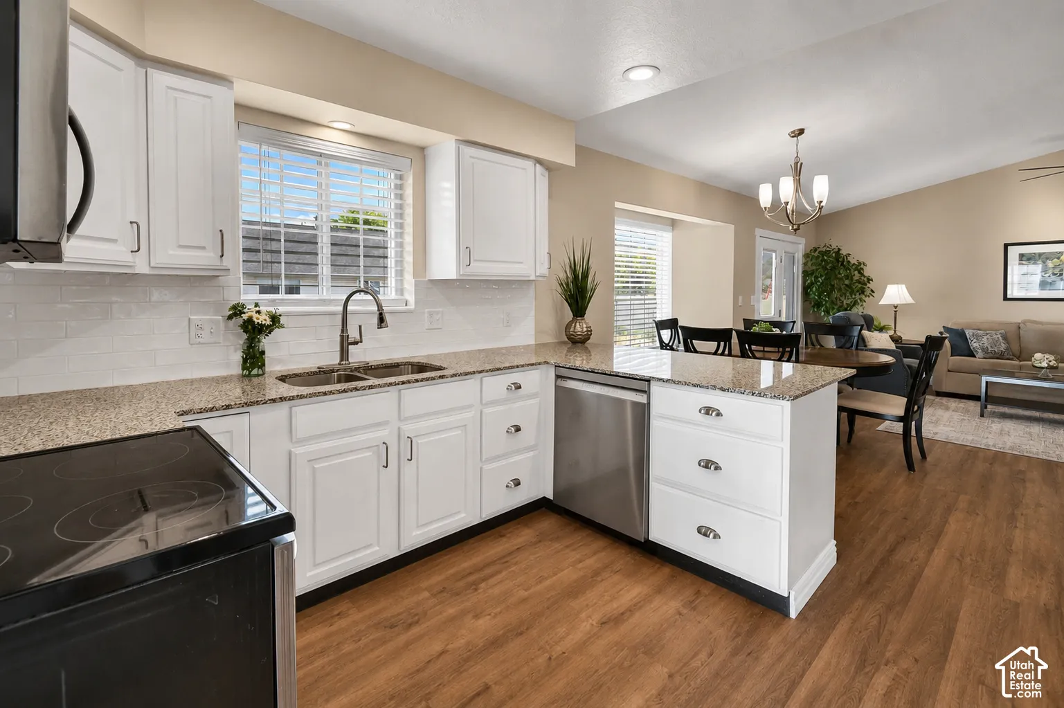 White cabinetry with dark hardware, a double basin sink, and stainless steel appliances