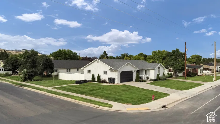 Single-story residence featuring a white stucco exterior and a dark gray roof