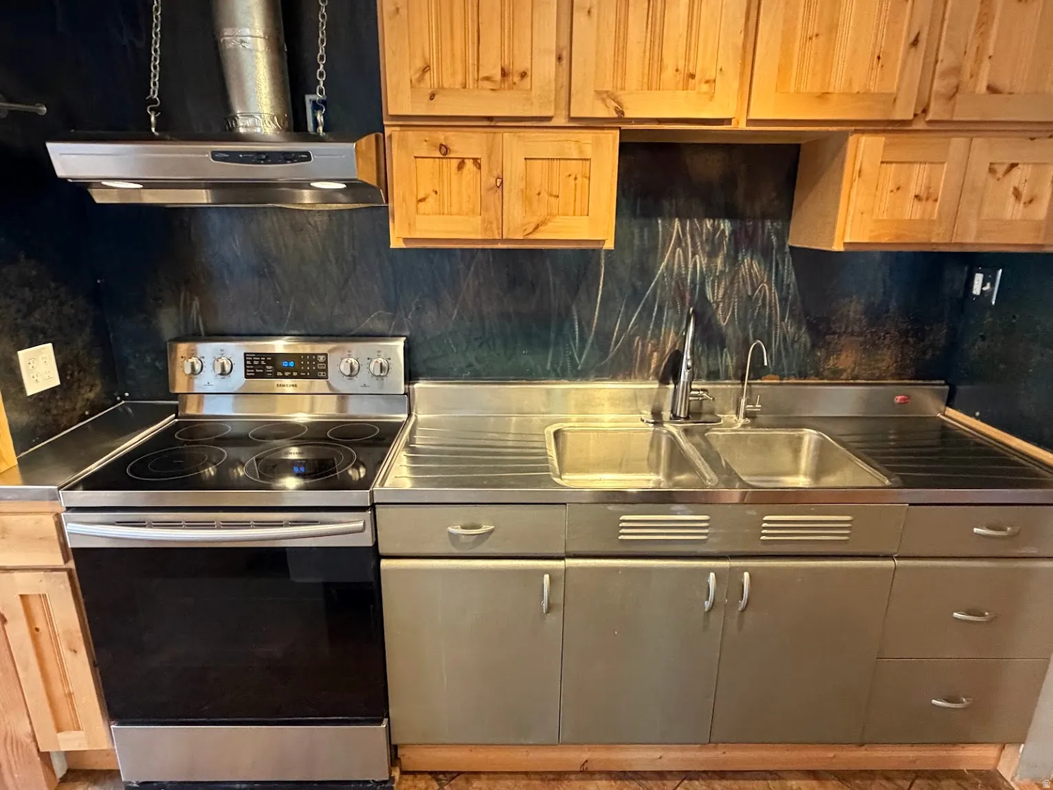 Stainless steel appliance suite, dual basin sink, and wood-finish cabinetry