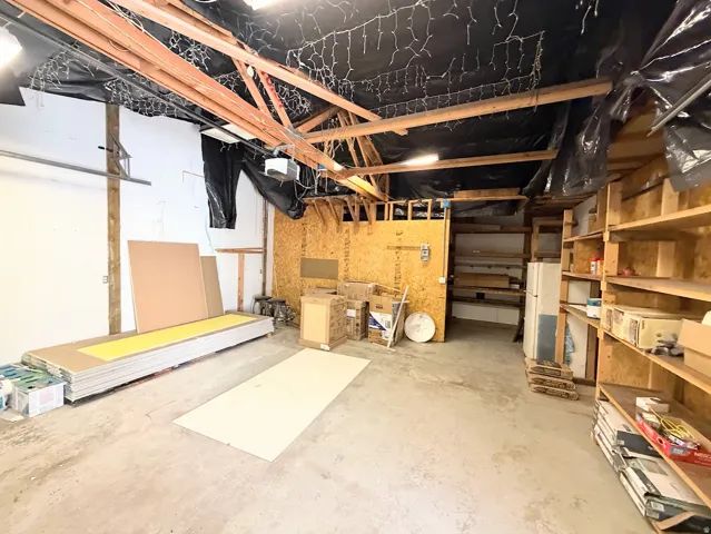 Concrete flooring with exposed ceiling joists and built-in wood shelving units