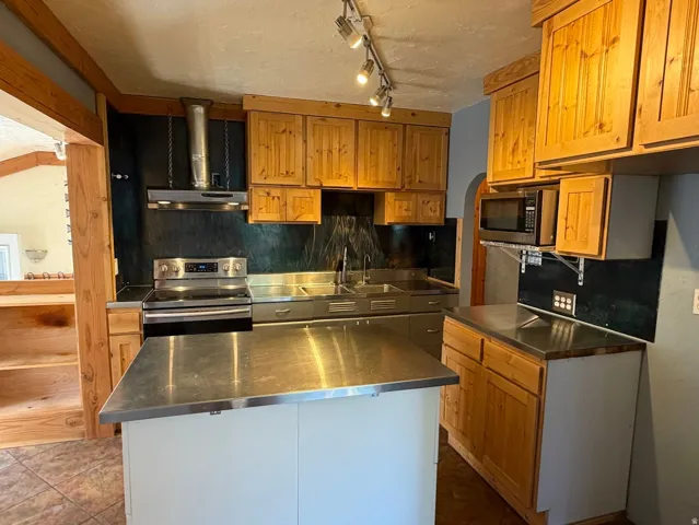 Main Floor Kitchen with Real Hood & Stainless Steel Appliances & Countertops.