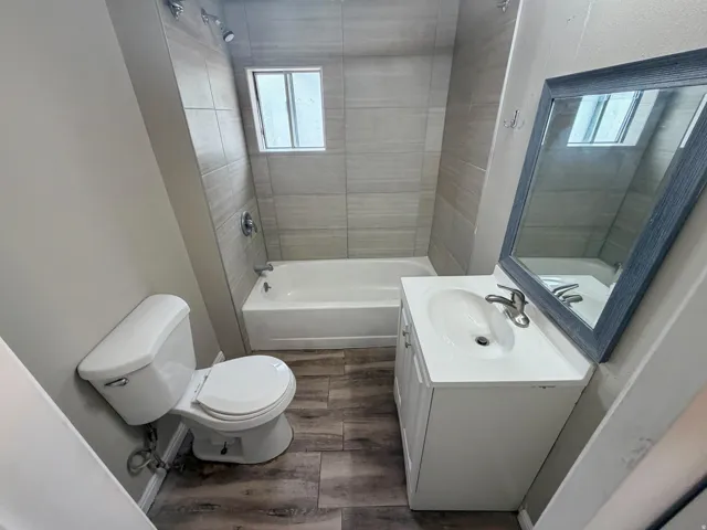 Wood-finish flooring with a white vanity and integrated sink