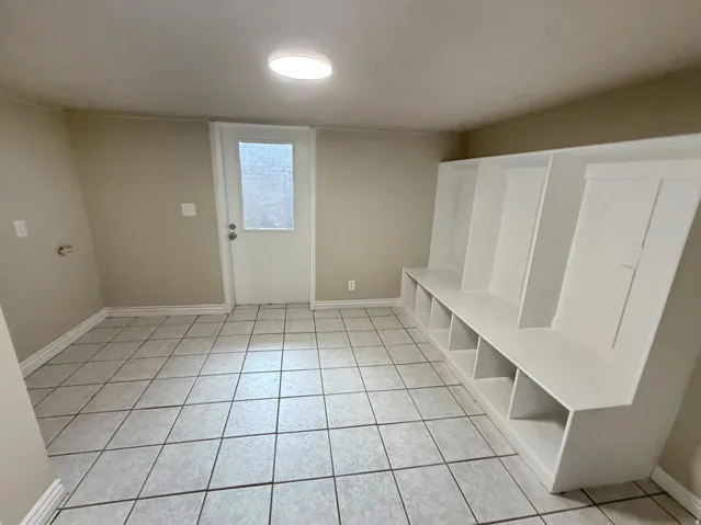 Tile flooring, built-in storage bench, and rear access door