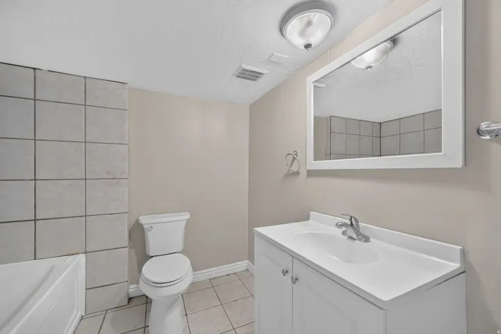 White vanity with integrated sink, chrome faucet, and white framed mirror