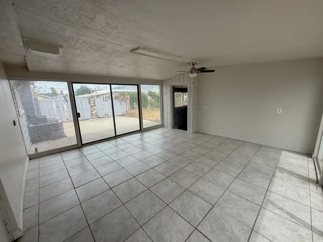 Tile flooring, expansive glass sliding doors, built-in ceiling lighting, and a ceiling fan
