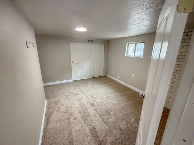 Carpeted room with neutral wall tones, white trim, and a window