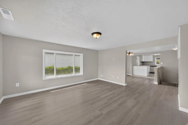 Wood-finish flooring throughout, neutral wall tones, and recessed lighting