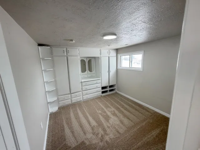 Built-in white cabinetry, integrated shelving, and a vanity area with mirrors