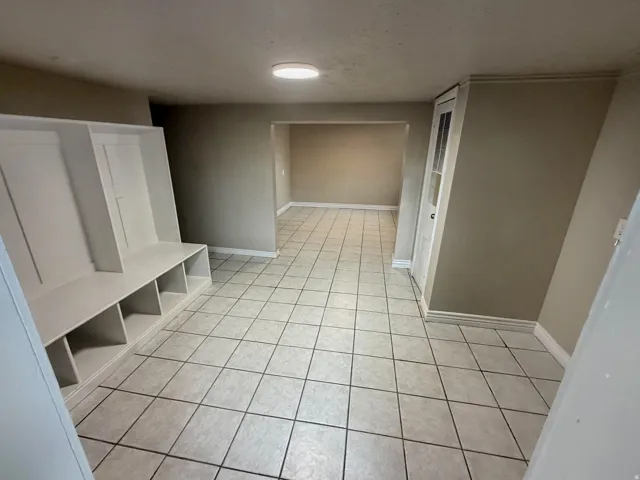 Tile flooring, built-in storage unit, recessed lighting, interior door with glass paneling, neutral wall paint