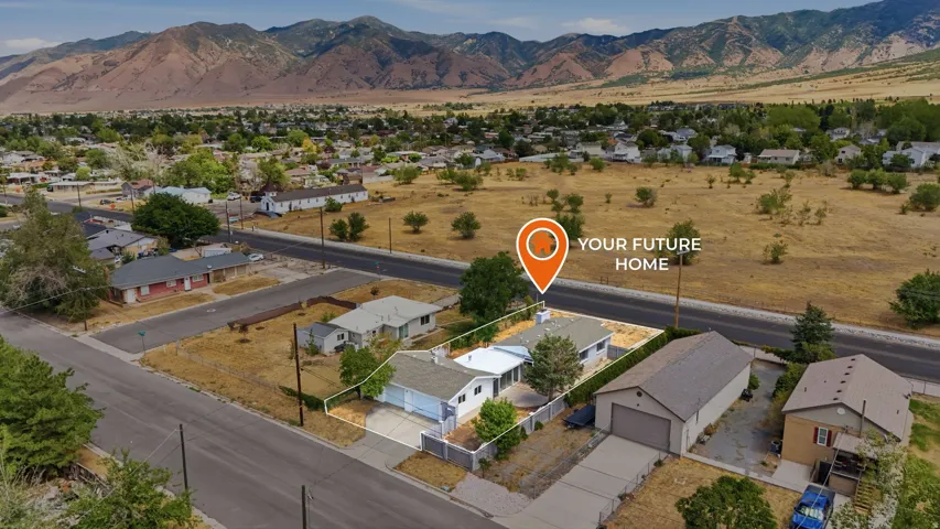 Single-story residence with an attached garage, paved driveway, and perimeter fencing