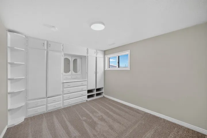 Built-in storage solutions with white cabinetry, integrated dresser, and corner shelving