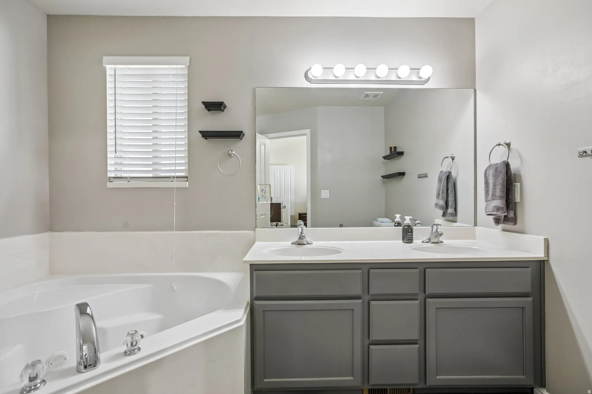 Corner soaking tub with chrome fixtures