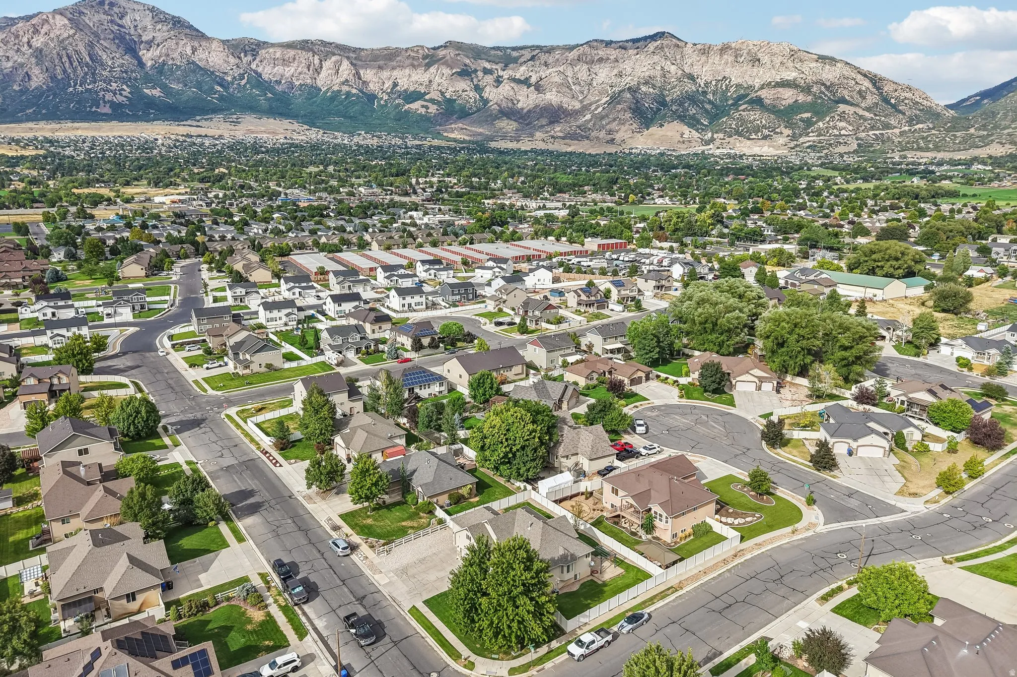 Residential neighborhood with established streets and mature landscaping, set against a mountainous backdrop