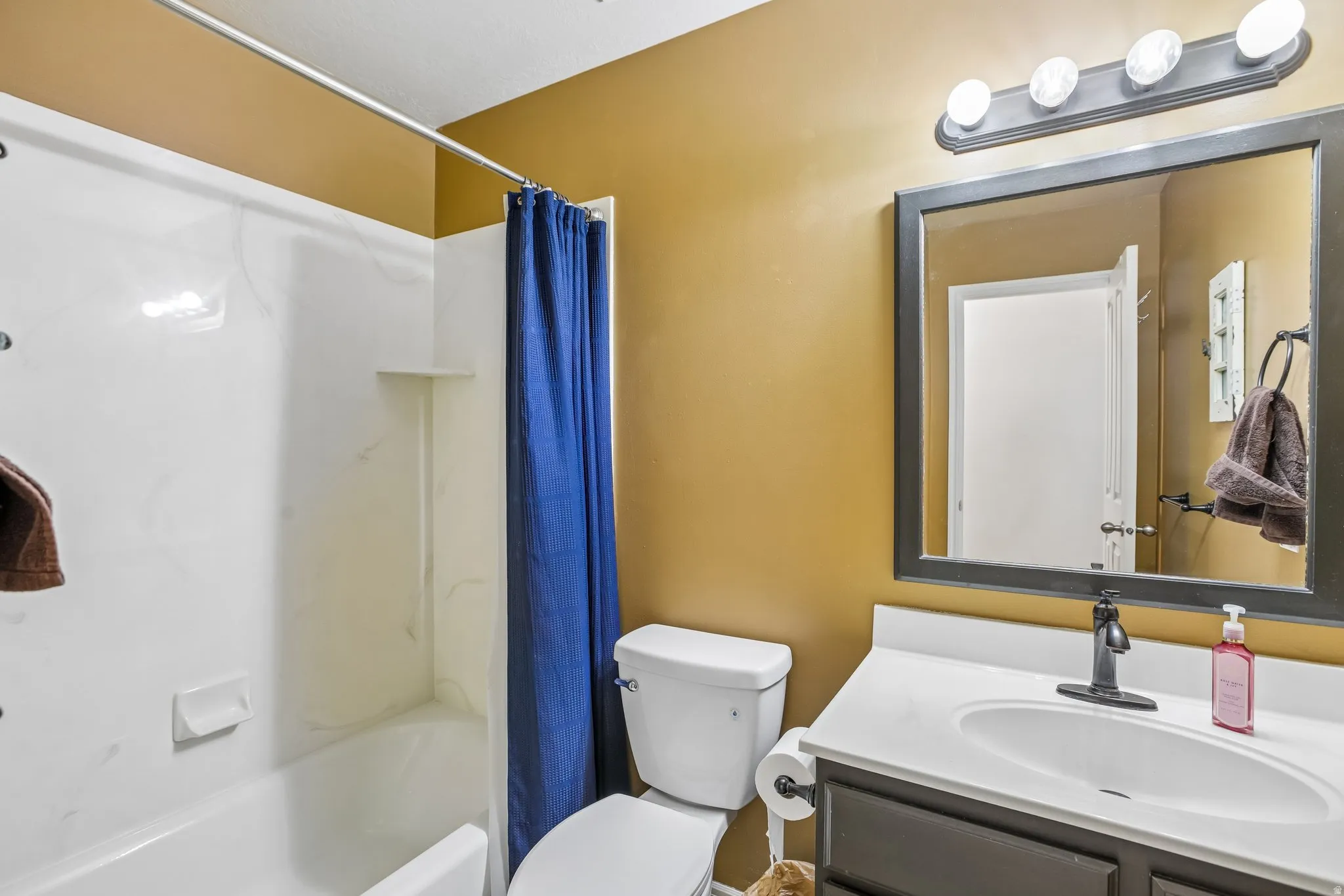 White vanity with integrated sink, dark wood-finish cabinetry, and black-finish faucet