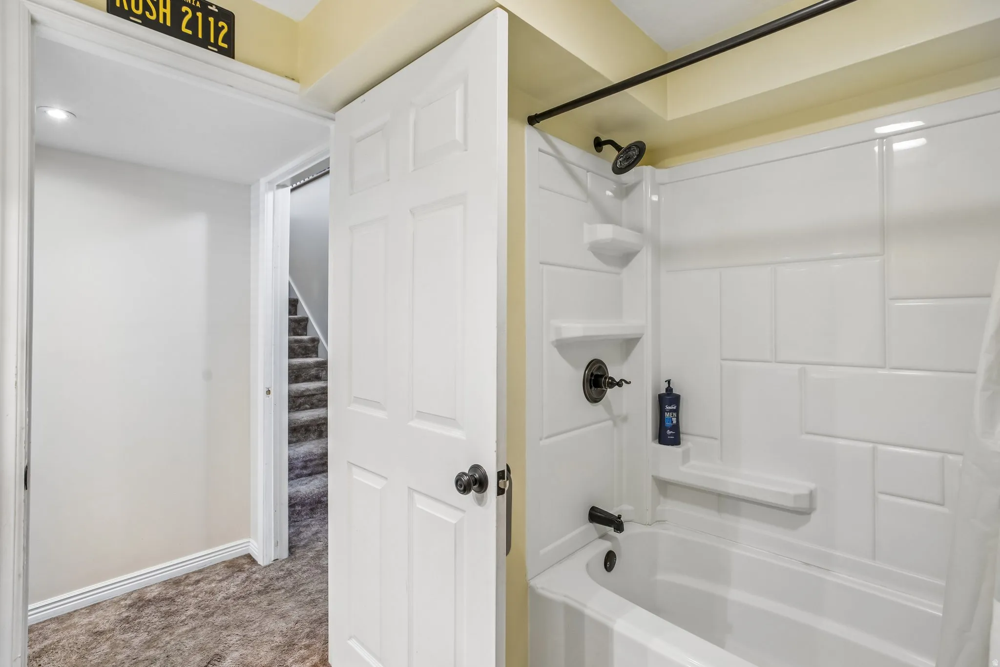 Tub/shower combination with white subway tile-style surround and matte black fixtures