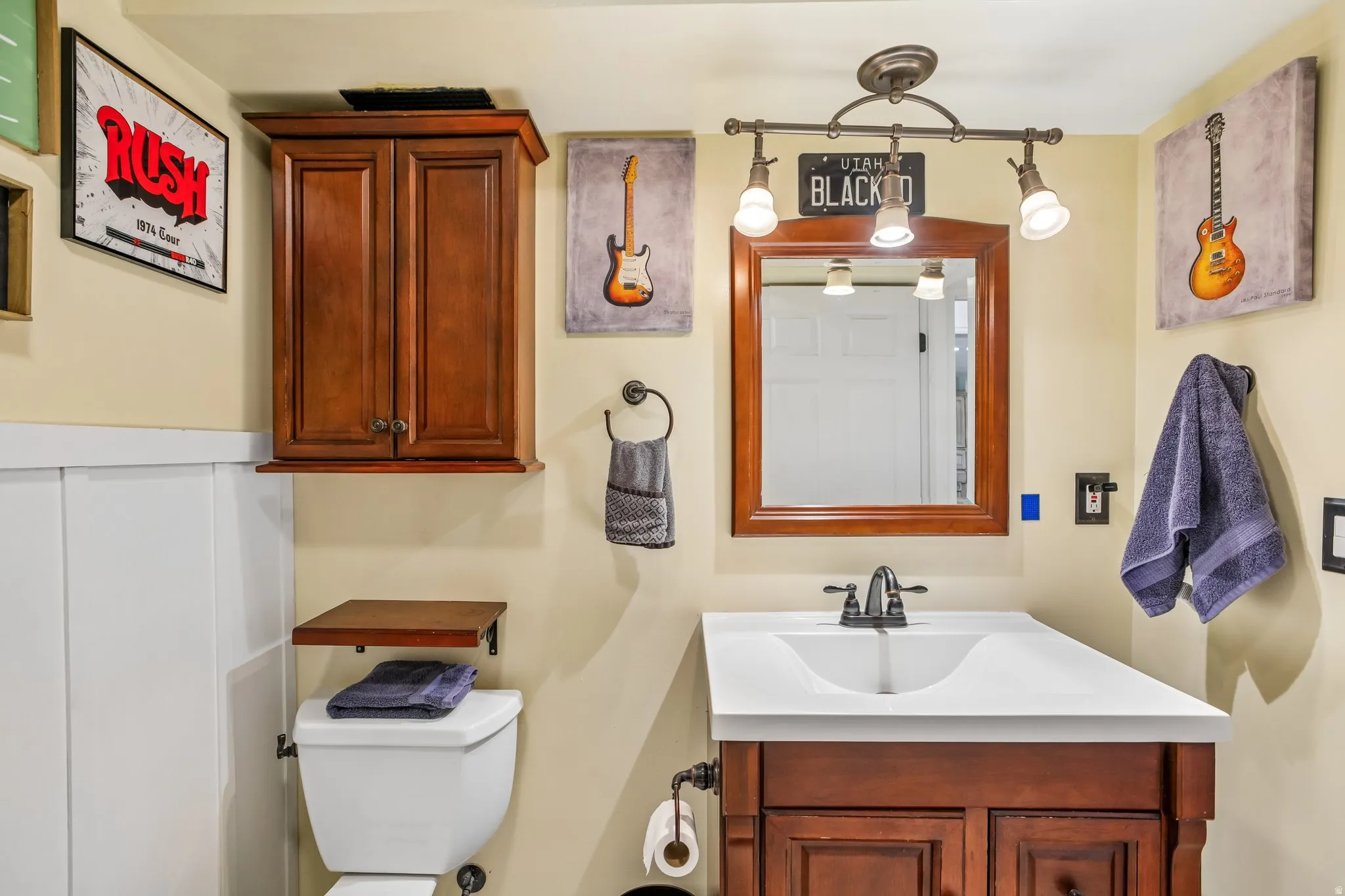 Vanity with an integrated white sink, dark wood-finish cabinetry, and a framed mirror